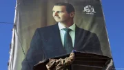 sirio arranca un cartel de Bashar al Asad