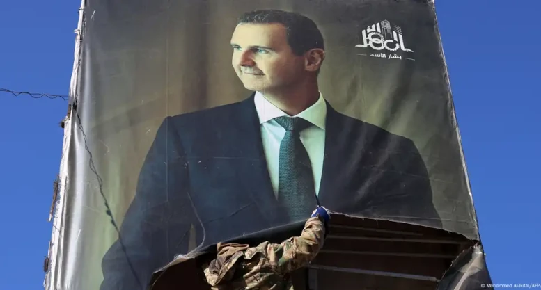 sirio arranca un cartel de Bashar al Asad